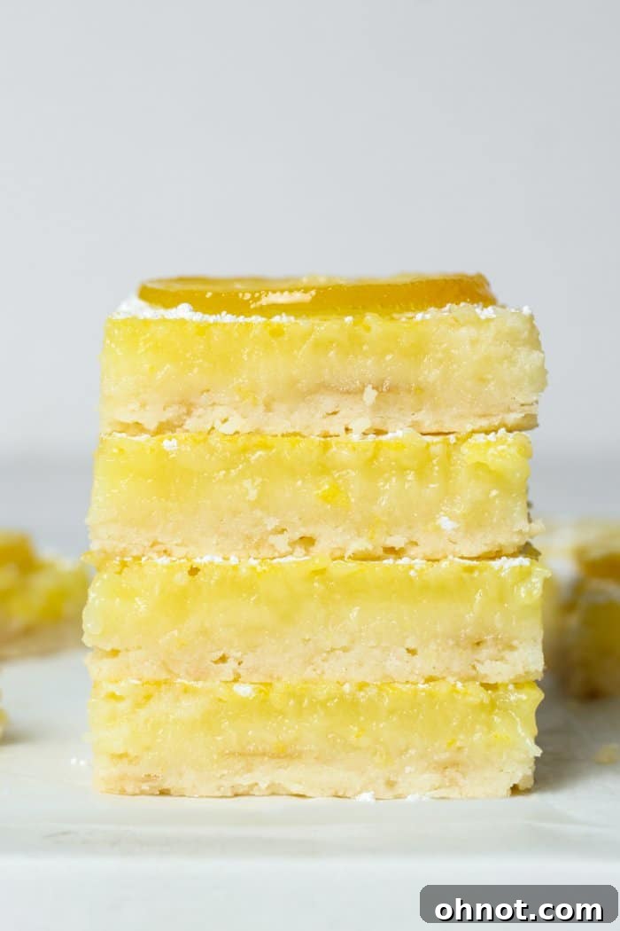 Stack of perfectly cut gluten-free lemon bars, showcasing their distinct layers.