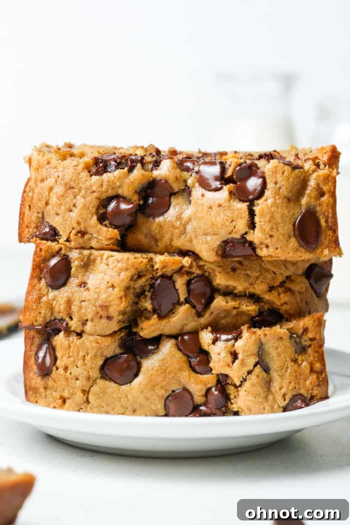Oat flour banana bread with chocolate chips, sliced on a wooden board.