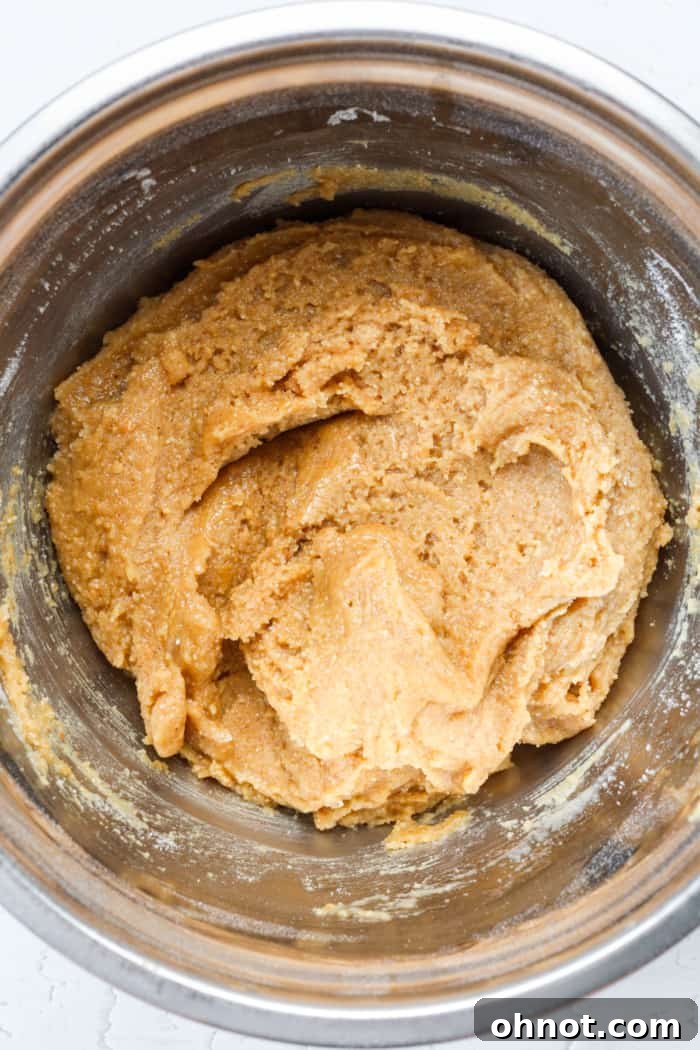 Thick peanut butter cookie dough in a mixing bowl, ready for shaping.