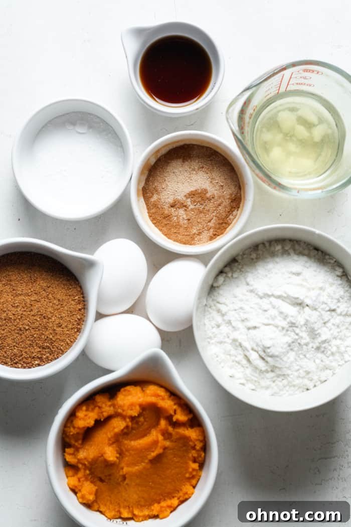 Assortment of pumpkin bread ingredients including pumpkin, eggs, flour, and spices.