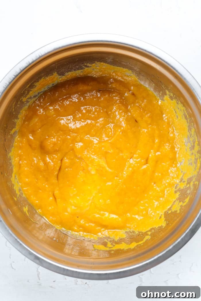 Orange pumpkin bread batter in a mixing bowl.