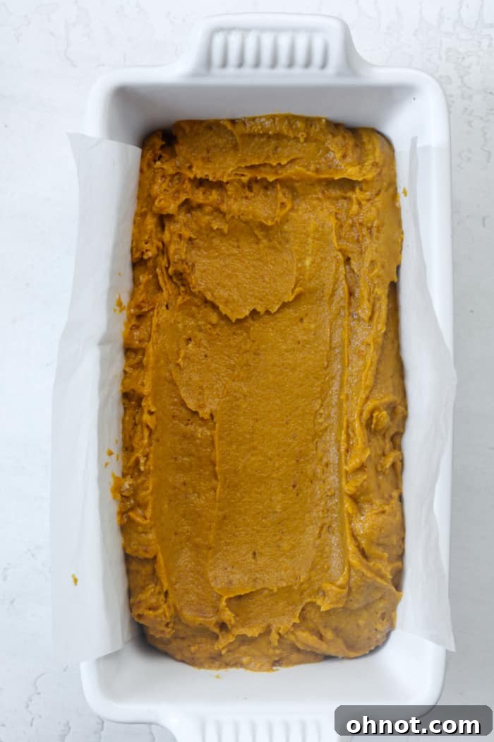 Bread pan filled with pumpkin bread batter.