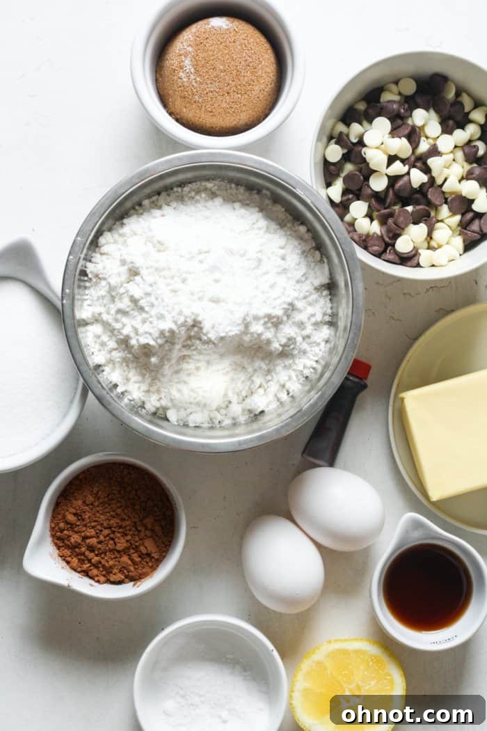 Assorted baking ingredients for red velvet cookies laid out on a table, including flour, sugar, butter, and cocoa powder.