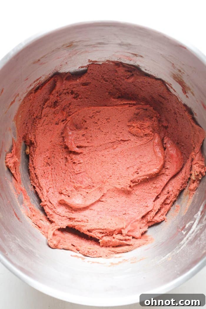 Vibrantly red cookie batter in a mixing bowl.