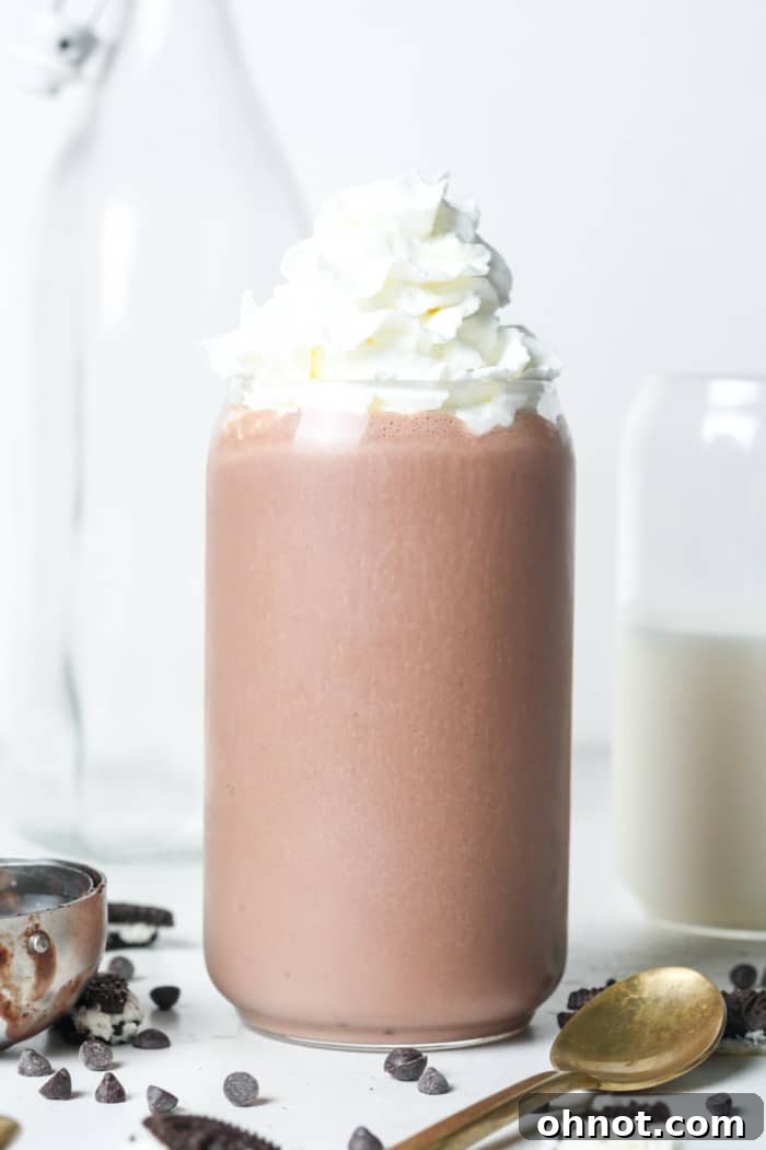 A refreshing vegan chocolate milkshake in a clear cup, perfectly blended and ready to drink.
