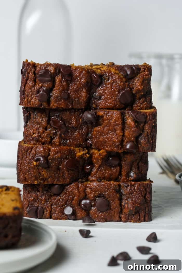 A beautifully stacked display of slices of almond flour pumpkin bread, featuring chocolate chips and a perfectly golden crust.