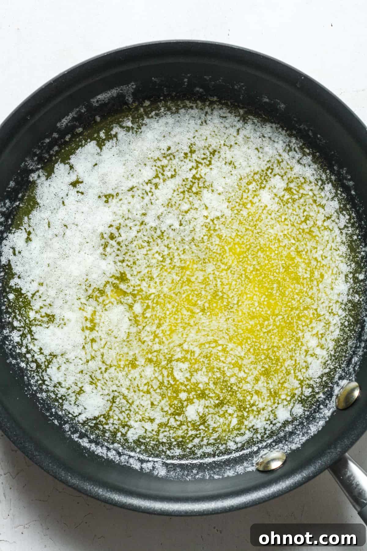 Melted butter in skillet, ready for the next step in making blondies.