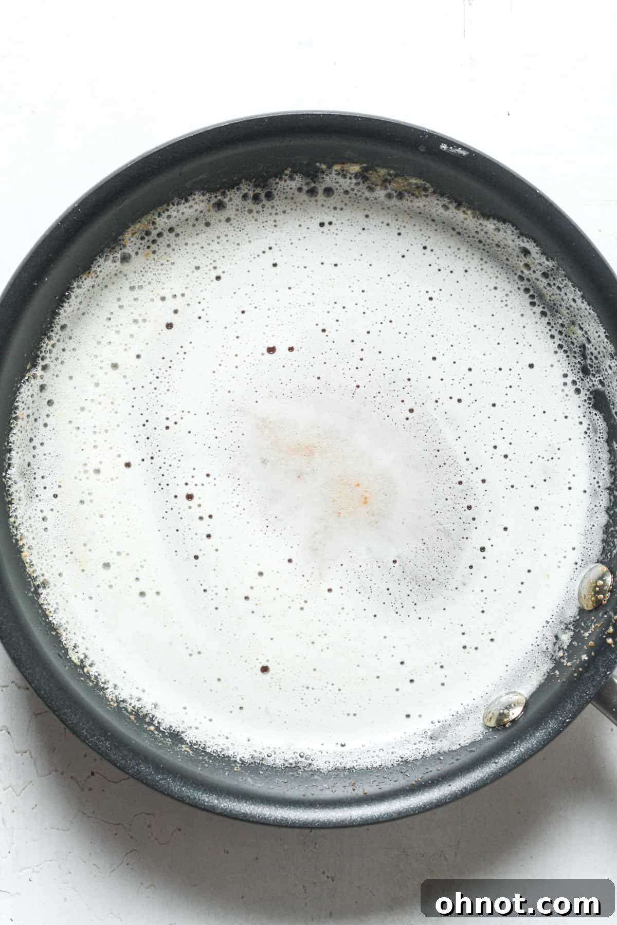 Foamy butter in skillet, indicating the browning process for a richer flavor.