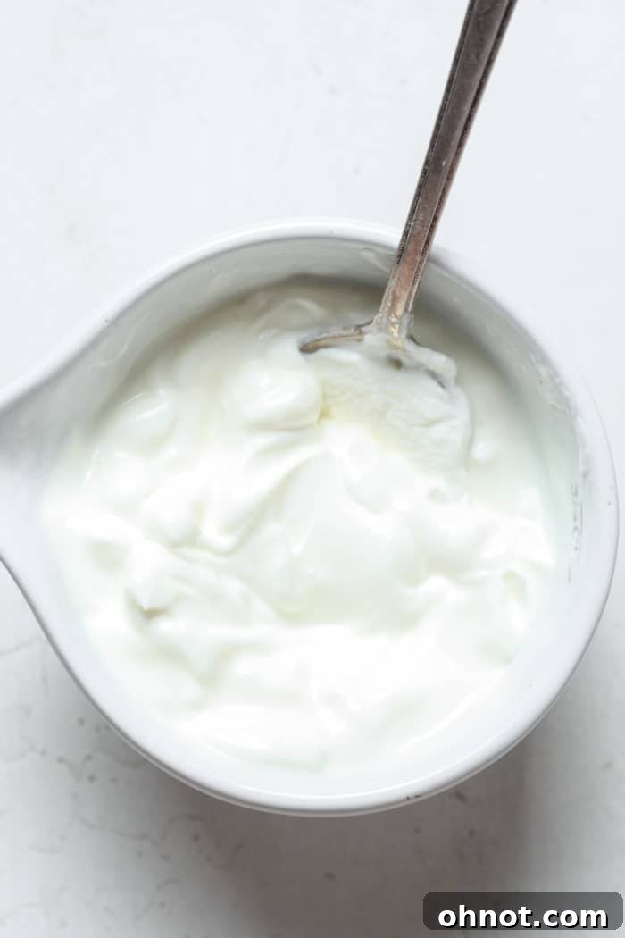 Vegan sour cream being stirred in a bowl to achieve a smooth texture.