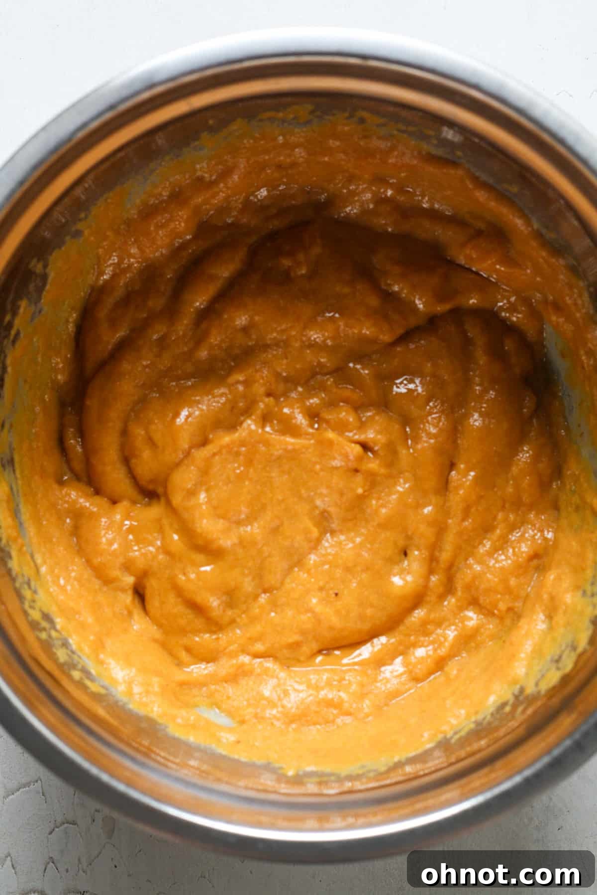 Smooth, creamy pumpkin batter in a mixing bowl after wet ingredients are combined.