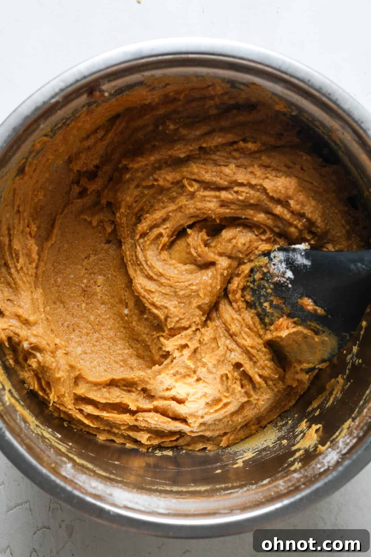Thick and rich pumpkin muffin batter in a bowl, ready for the final additions.