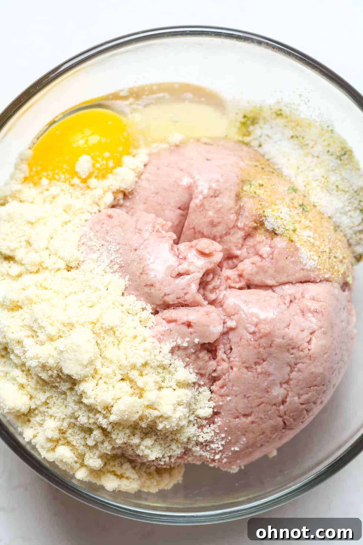 Ground turkey, egg, and almond flour in a mixing bowl before combining.