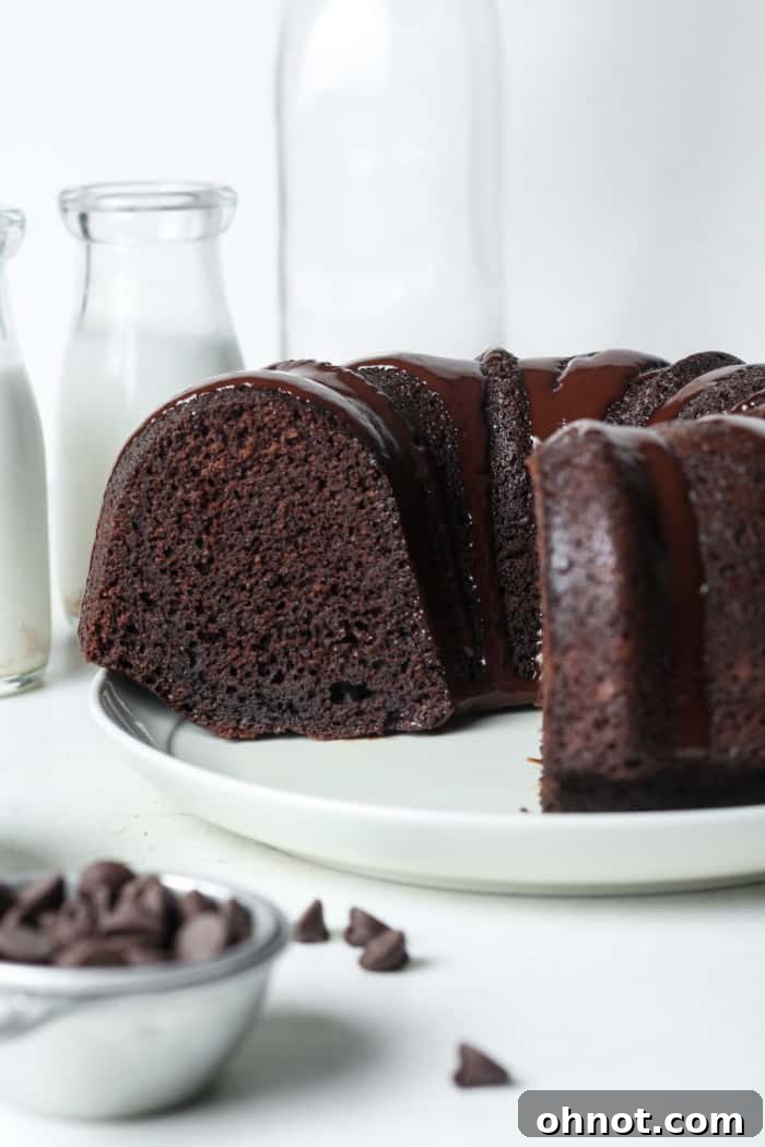 A beautifully glazed chocolate Bundt cake on a cooling rack, ready to be sliced and served.