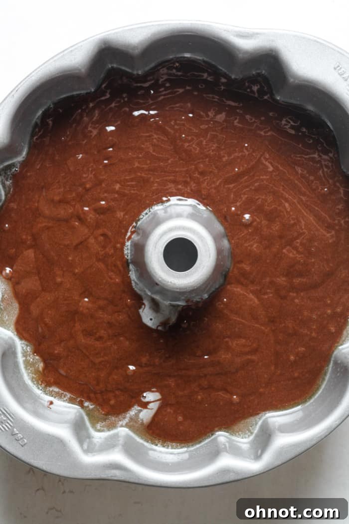 Unbaked chocolate Bundt cake batter poured into a Bundt pan, ready to go into the oven.