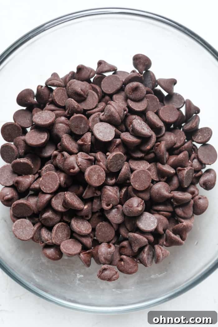 A glass bowl filled with chocolate chips, ready for melting into a glaze.