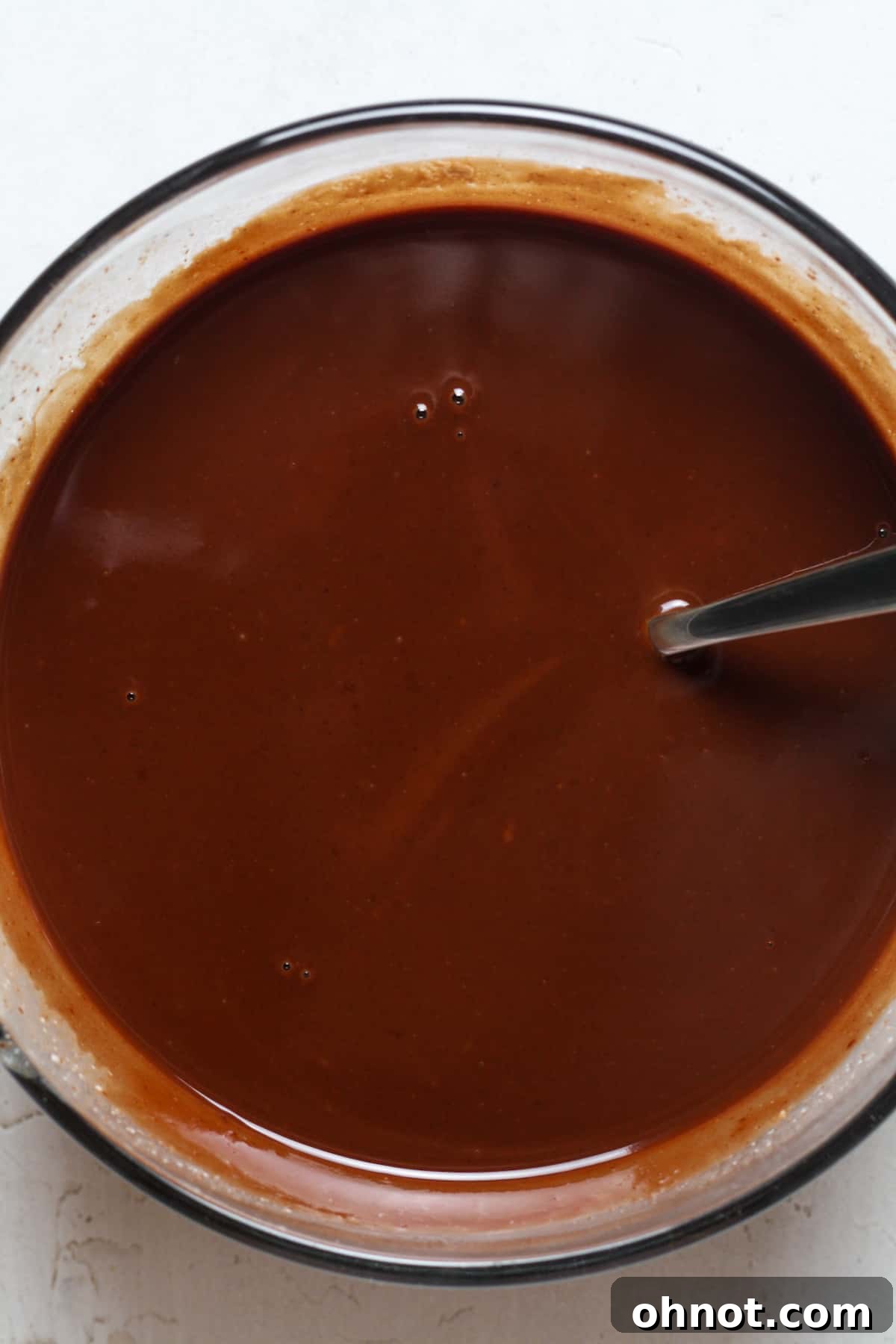 Smooth, glossy dairy-free chocolate glaze in a bowl, perfectly melted and ready.