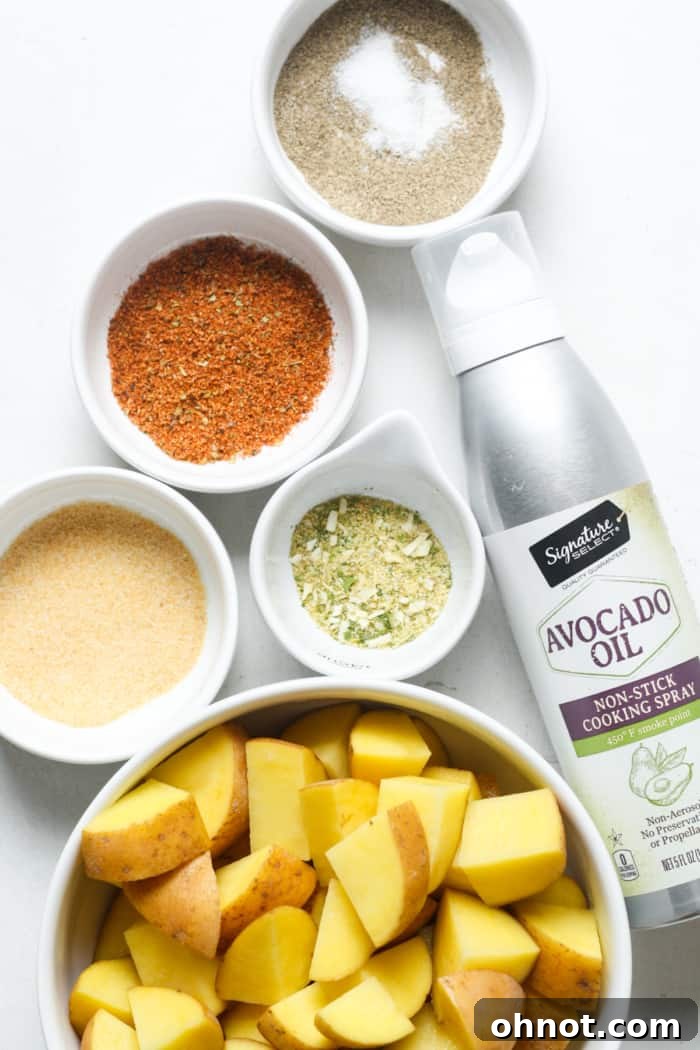 Fresh potatoes, avocado oil spray, and various spices laid out as ingredients for home fries.