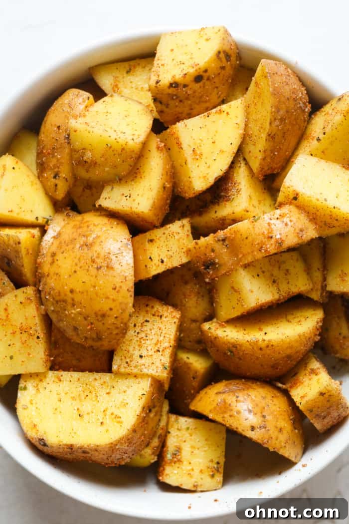 Diced potatoes in a mixing bowl, perfectly seasoned and ready for the air fryer.
