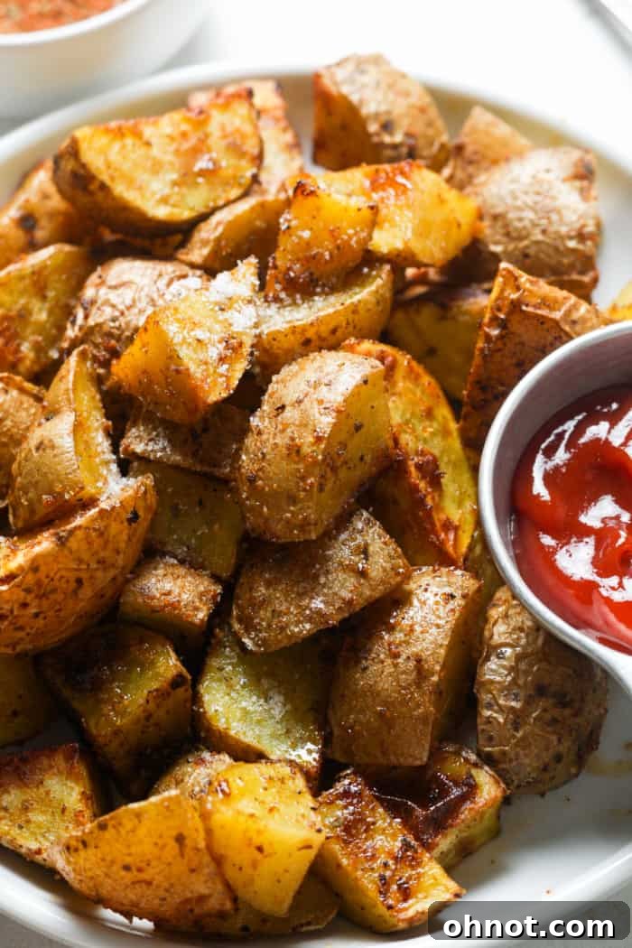 Close-up of golden-brown and crispy home fries on a plate, showcasing their perfect texture.