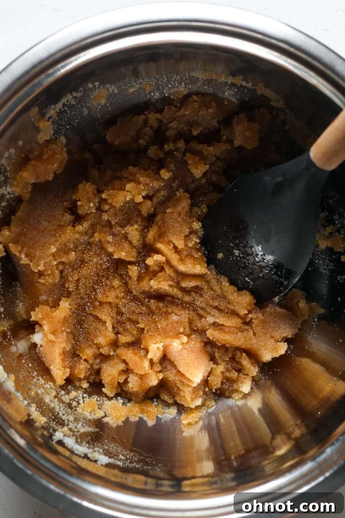 Melted coconut oil and sugars in a mixing bowl.