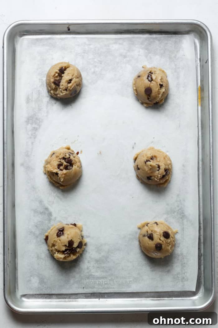 Cookie dough balls neatly arranged on a baking pan.