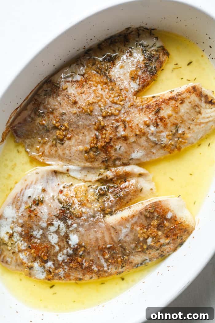 Baked tilapia fillets in a pan, ready to be served.