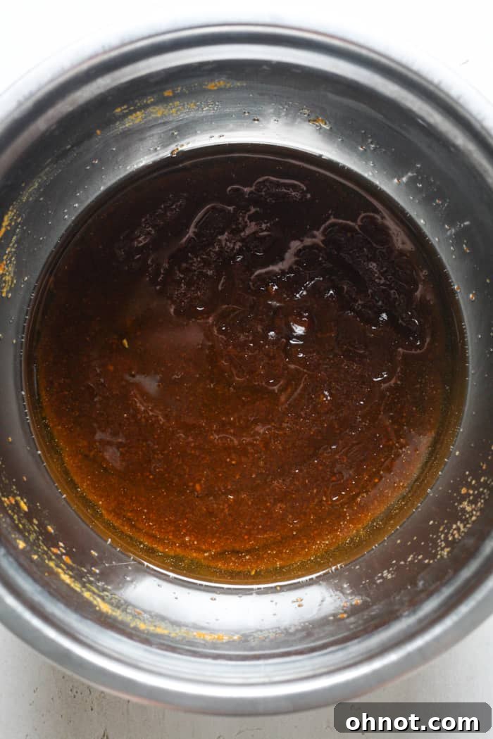 Pumpkin cookie batter in a bowl, appears slightly greasy.