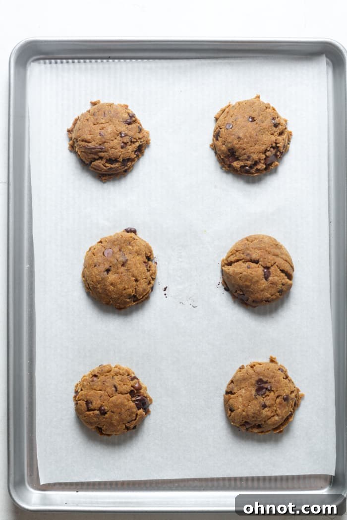Freshly baked pumpkin cookies on a baking sheet.