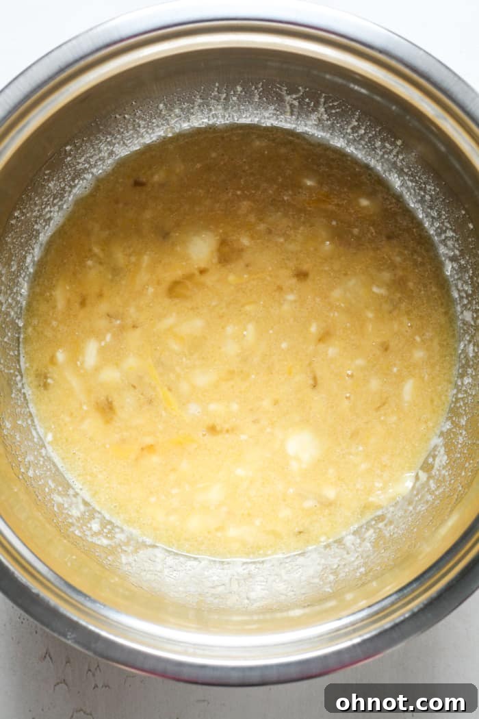 Mashed bananas mixed with wet ingredients in a bowl.