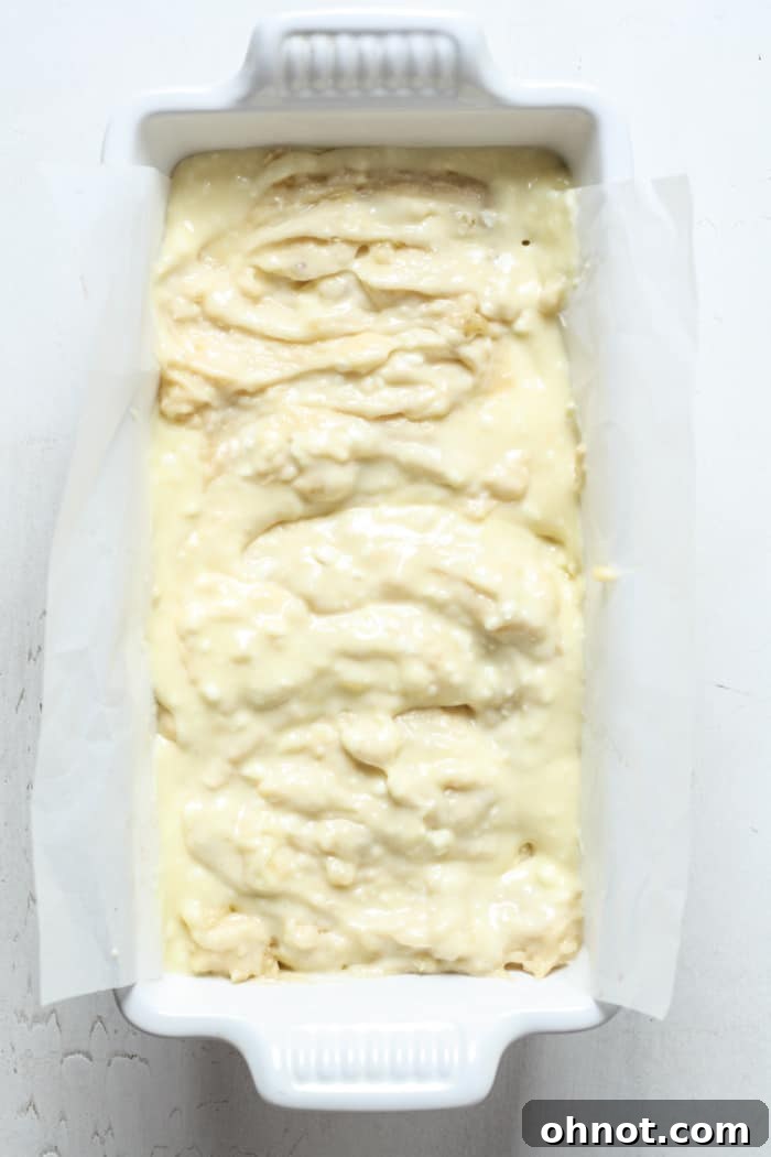 Cream cheese and banana bread batter swirled together in a loaf pan.