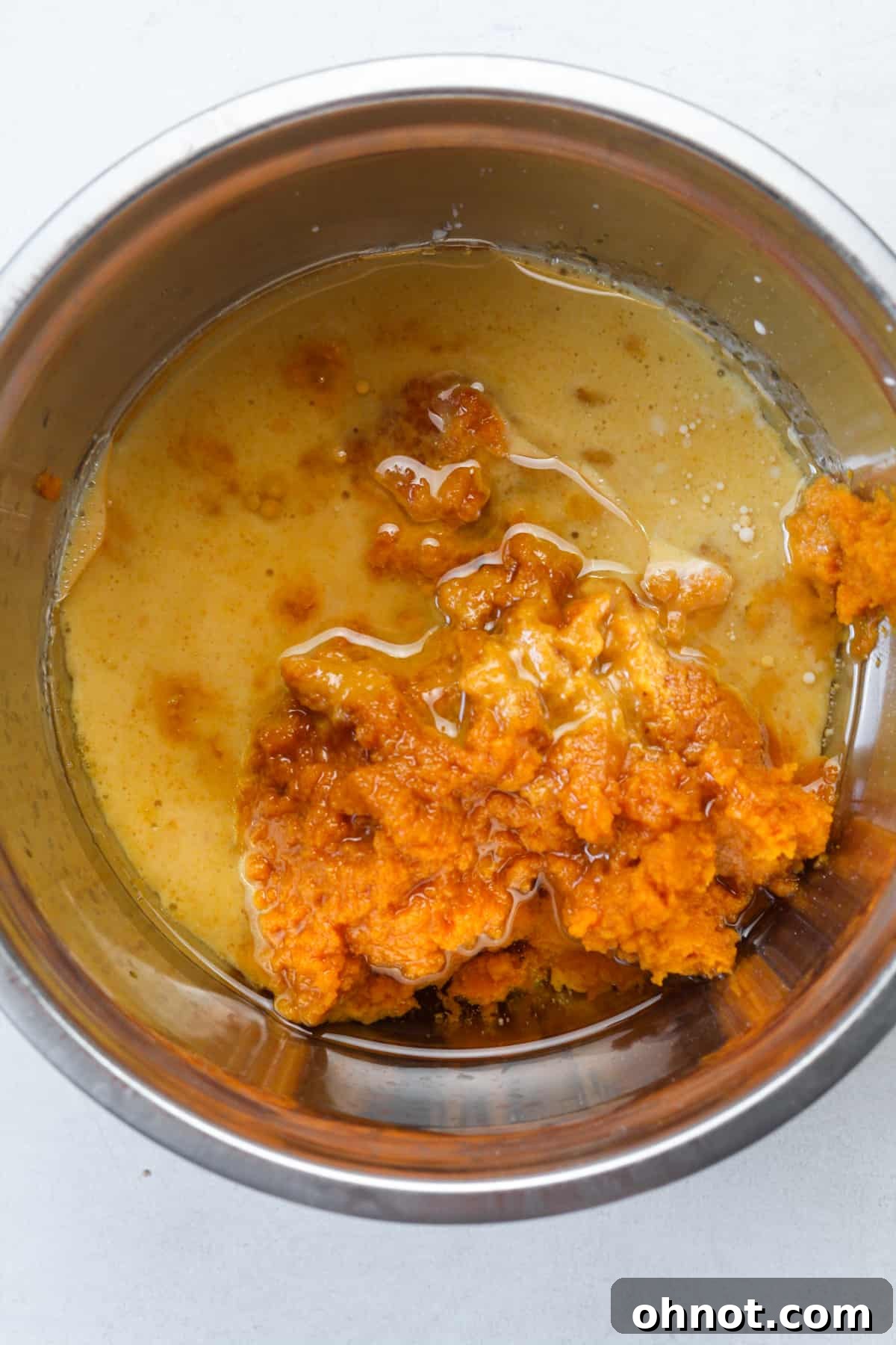 Combining pumpkin puree with melted coconut oil.