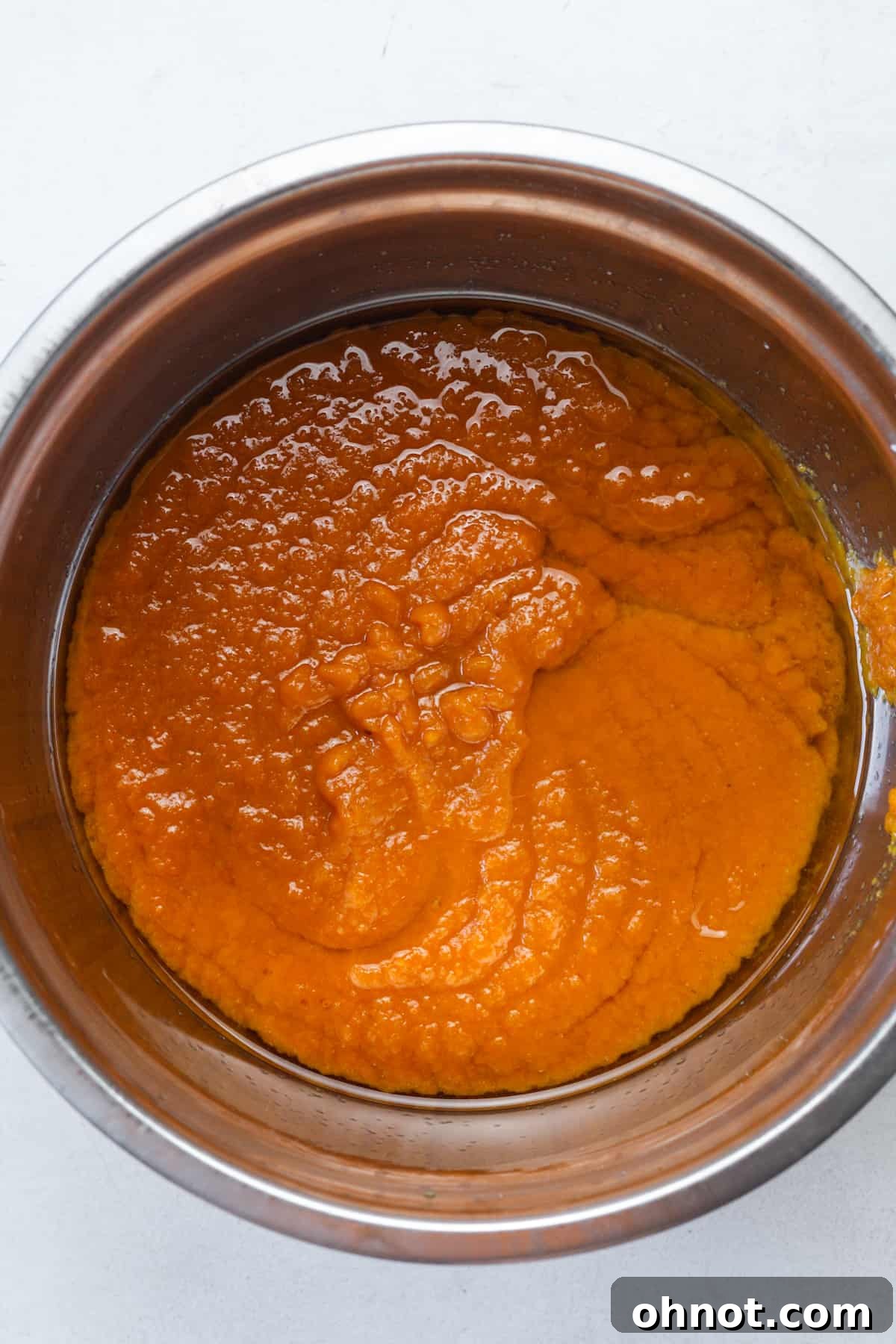 Smooth orange muffin batter in a mixing bowl.