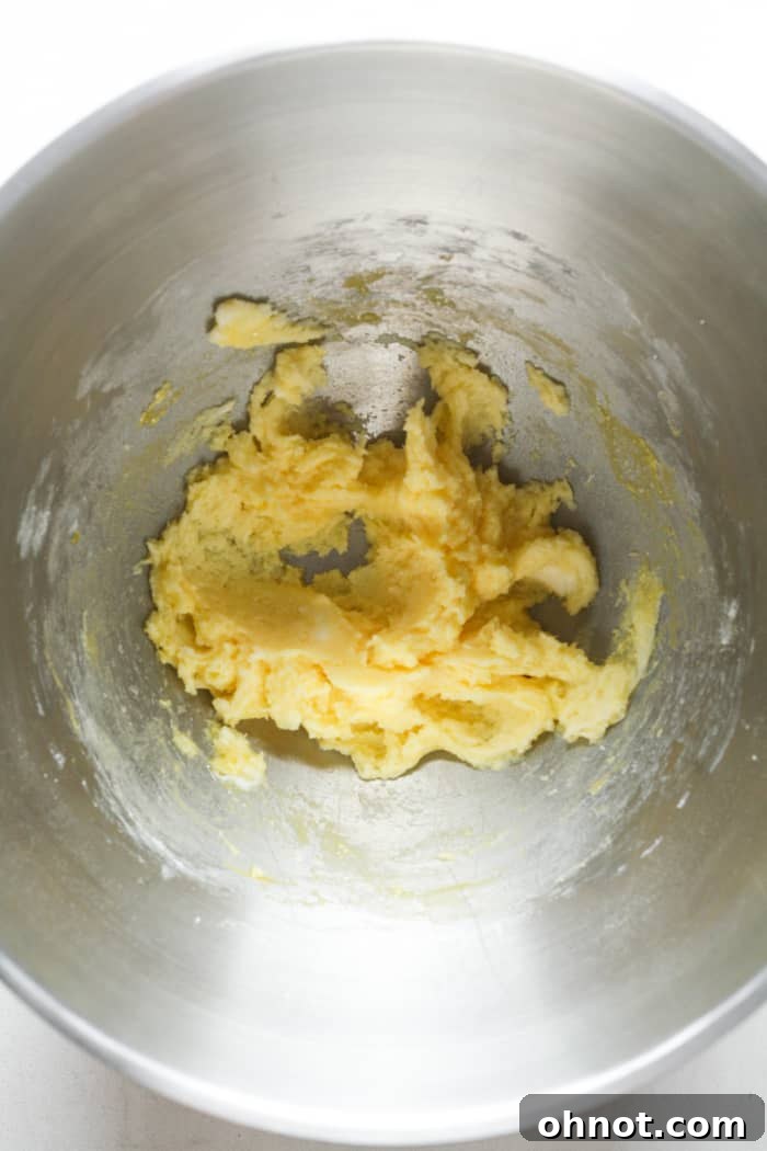 The mixing bowl now contains the yellow dough after vanilla and egg yolk have been added.