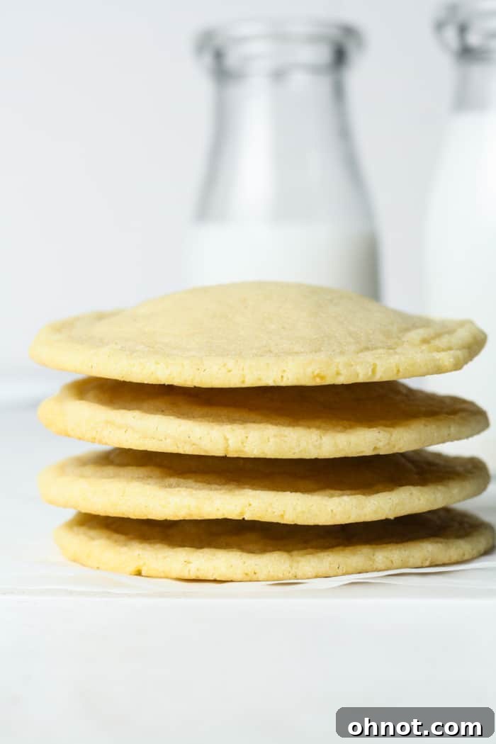 A stack of perfectly baked light sugar cookies, highlighting their soft texture.