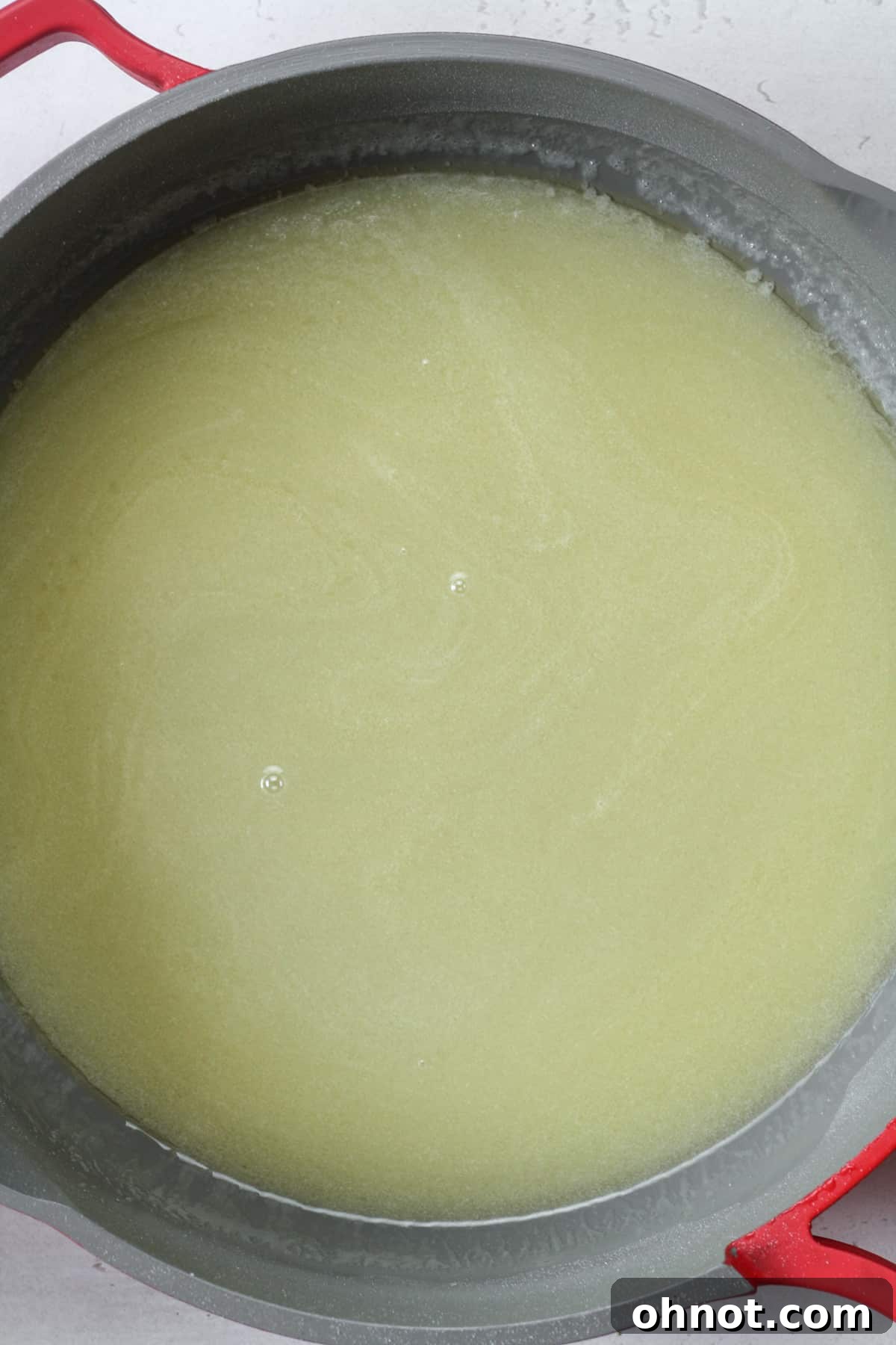 The sugar, vegan butter, and vegan milk mixture in a skillet, now fully dissolved and smooth, ready for the next step.