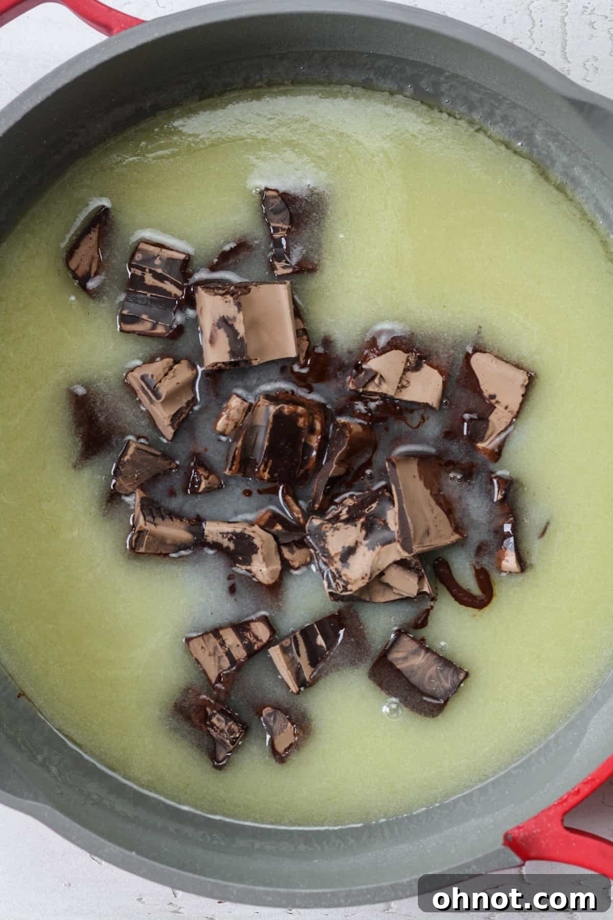 Finely chopped vegan chocolate being added to the warm butter and sugar mixture in a skillet.