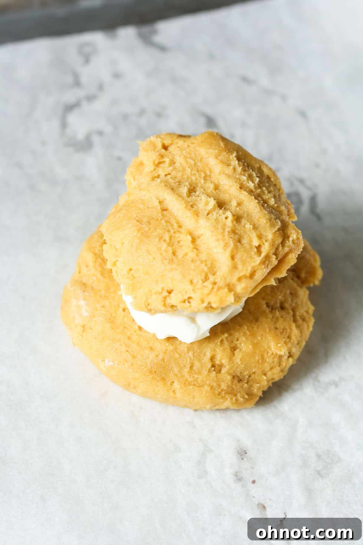 Stuffed pumpkin cookies with cream cheese filling sandwiched between two dough layers.