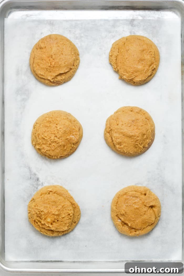 Freshly baked pumpkin cheesecake cookies, slightly puffed and golden at the edges.