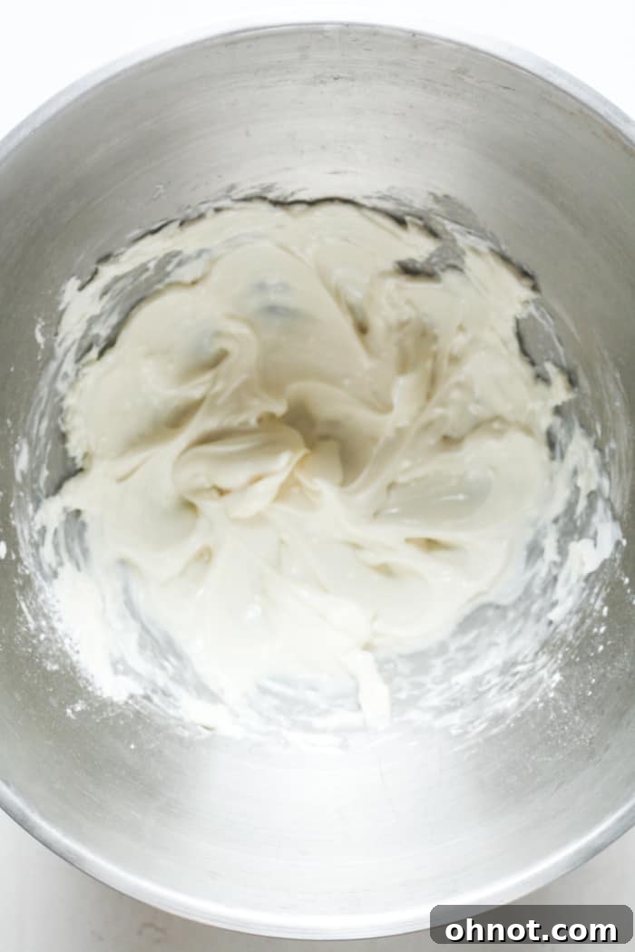 Smooth and creamy cheesecake filling in a stand mixer bowl.