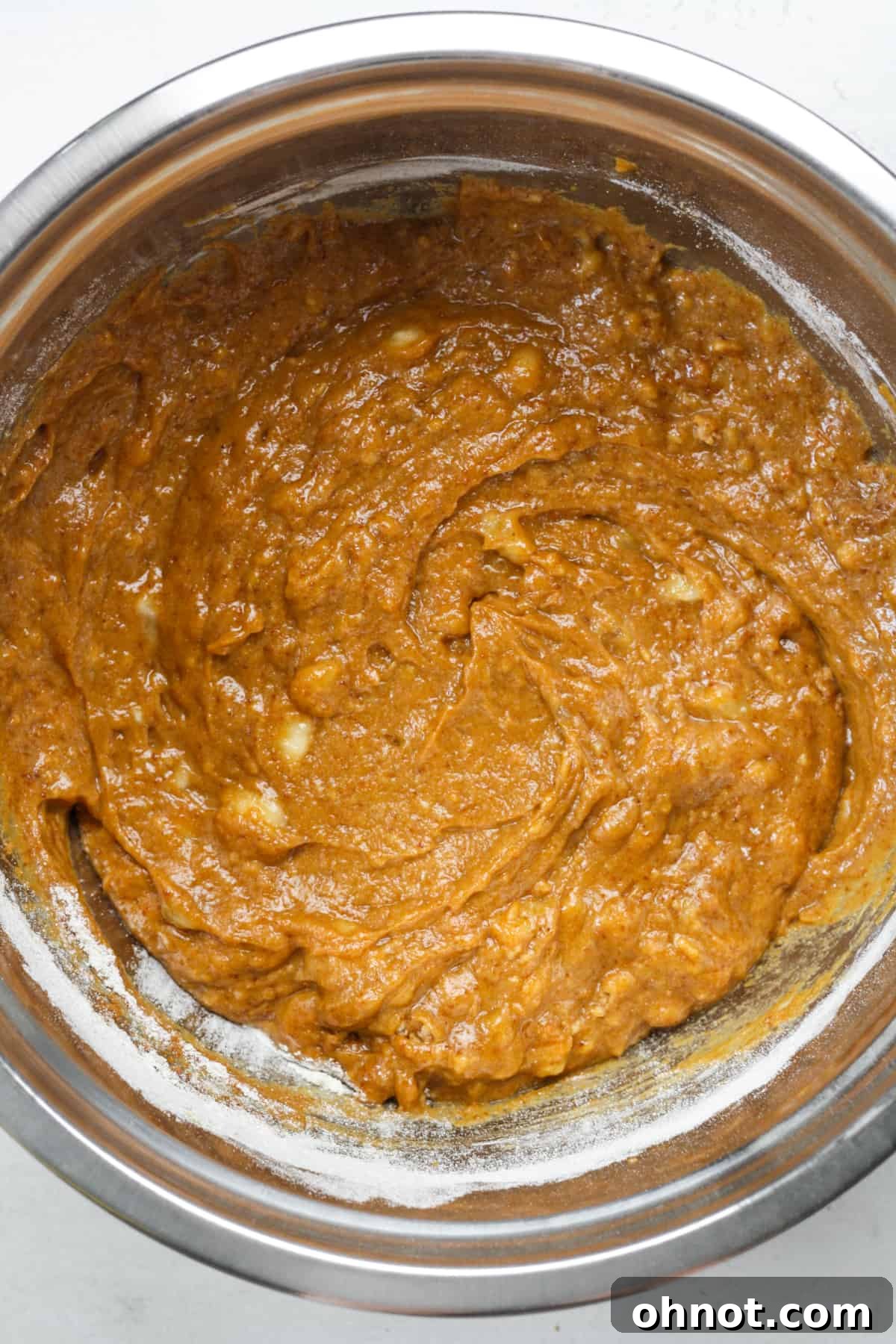 Pumpkin bread batter, rich and smooth, in a mixing bowl after all ingredients are combined.