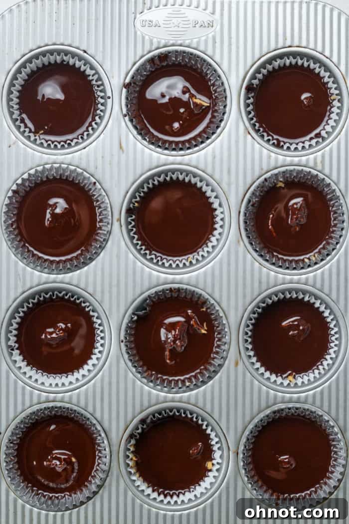 Melted chocolate covering the peanut butter layer in muffin liners, with sea salt.