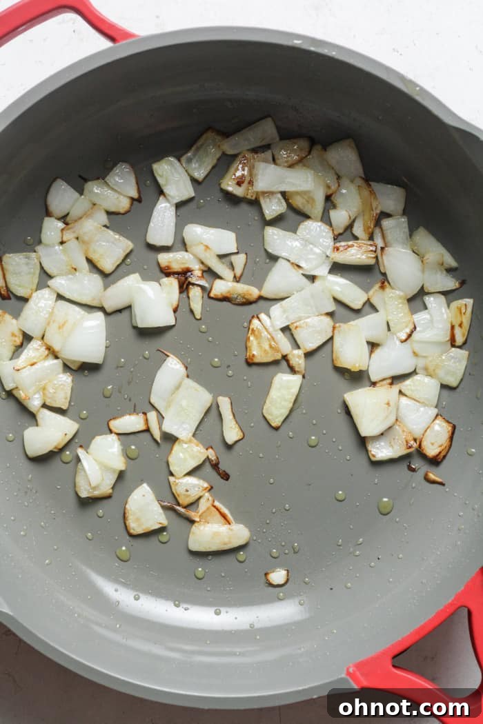 Finely chopped onions sizzling in a skillet with oil.