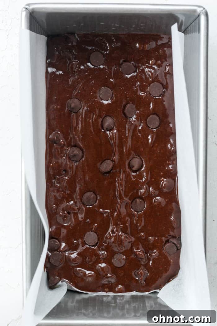 Bread pan with brownie batter spread evenly.