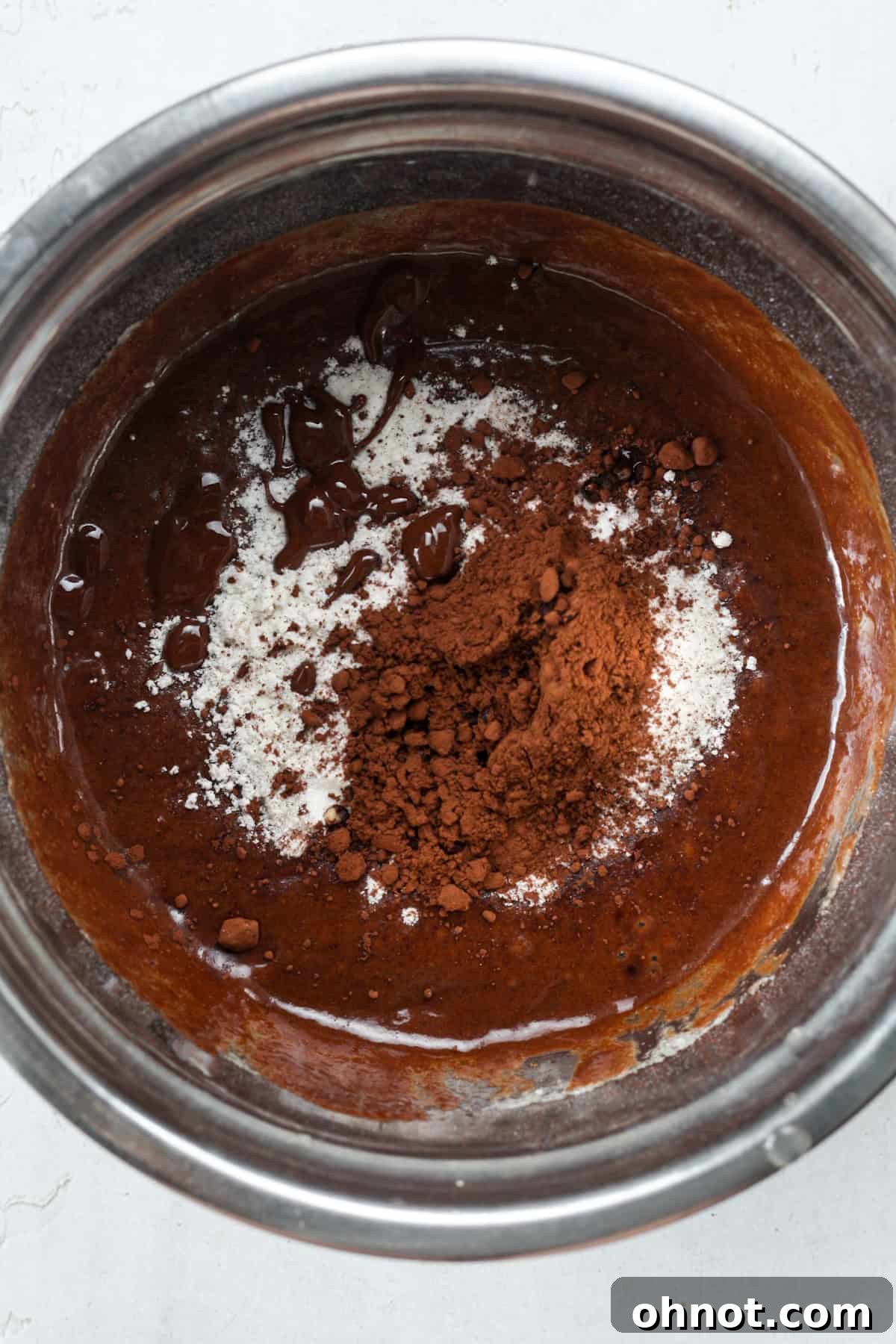 Brownie ingredients in bowl, including cocoa, flour, and vanilla.