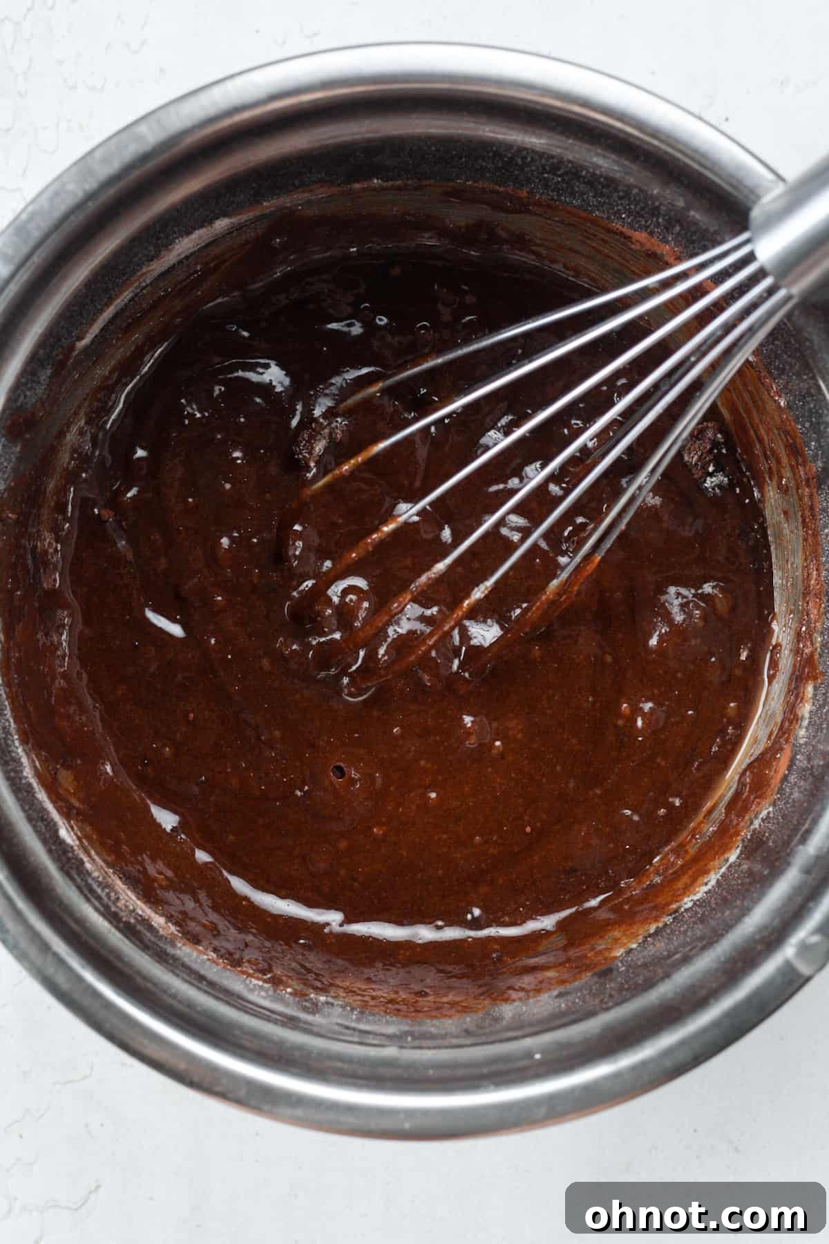 Raw brownie batter in a bowl, ready for baking.