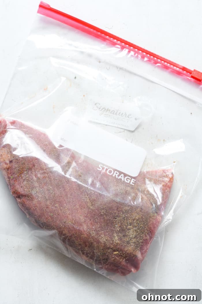 Seasoned tri tip steak sealed in a vacuum bag.