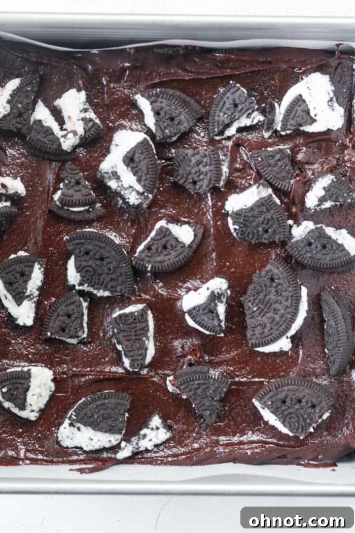 Crushed Oreo cookies sprinkled generously over the top of the brownie batter in the pan.