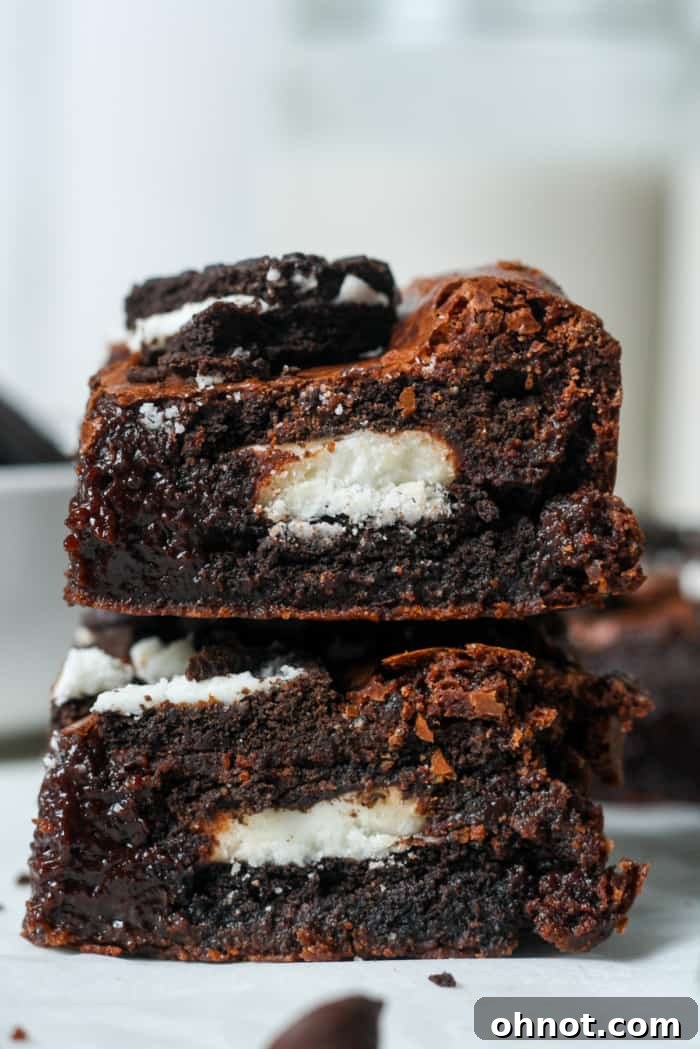 Two rich Oreo brownies, one with a bite taken, showcasing the delicious interior.