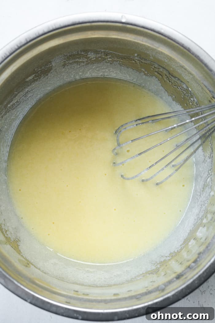 Light and frothy whisked egg and sugar mixture in a bowl.