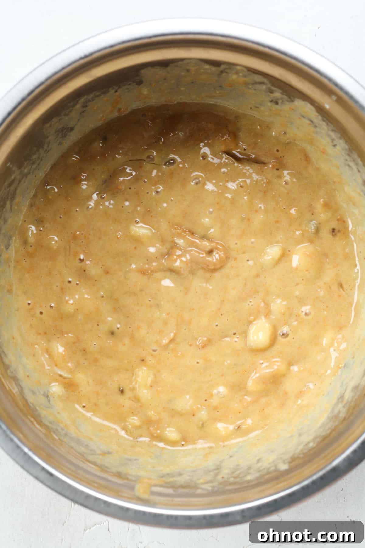 Smooth batter of mashed bananas, eggs, nut butter, and vanilla extract.